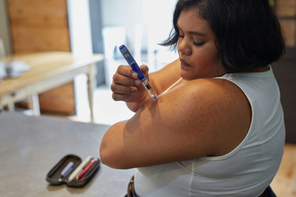 Women with diabetes injecting insulin into her arm 